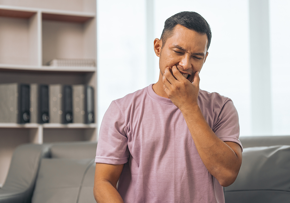 Man in pain showing signs of needing Urgent Dental Care