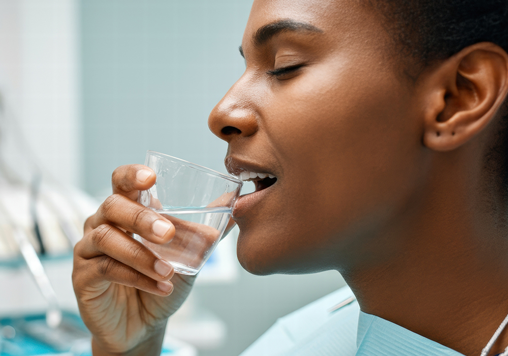 Woman rinsing mouth after emergency dental procedure