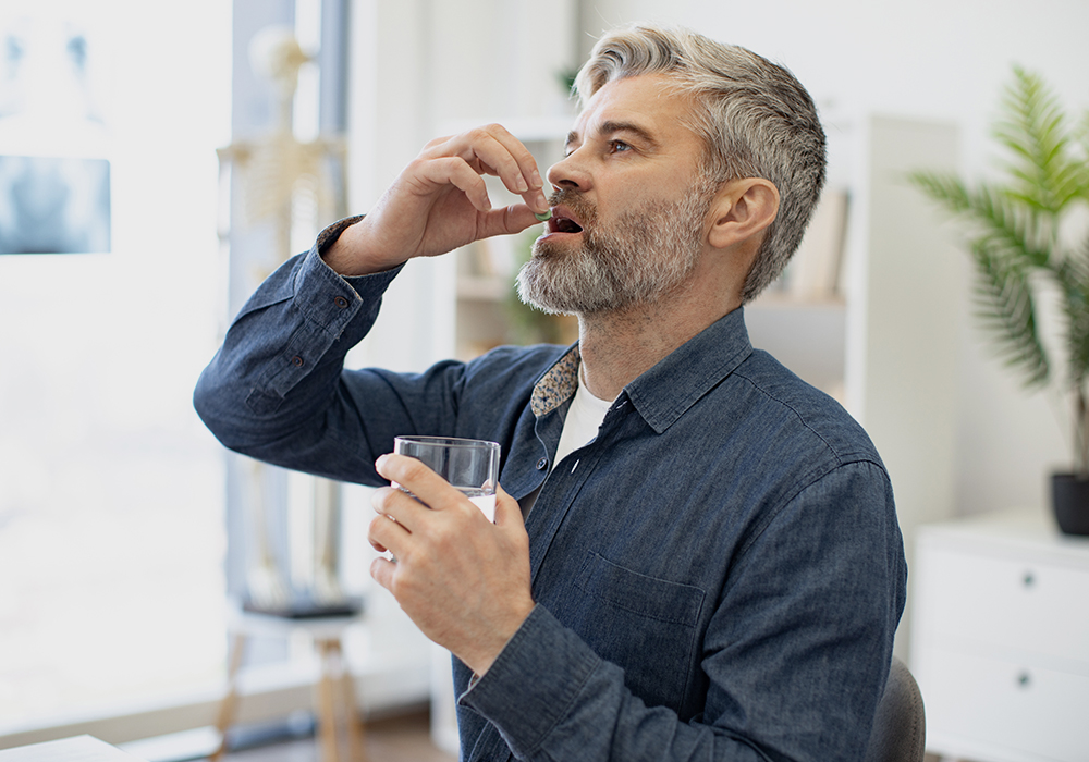 Man taking meds for tooth pain