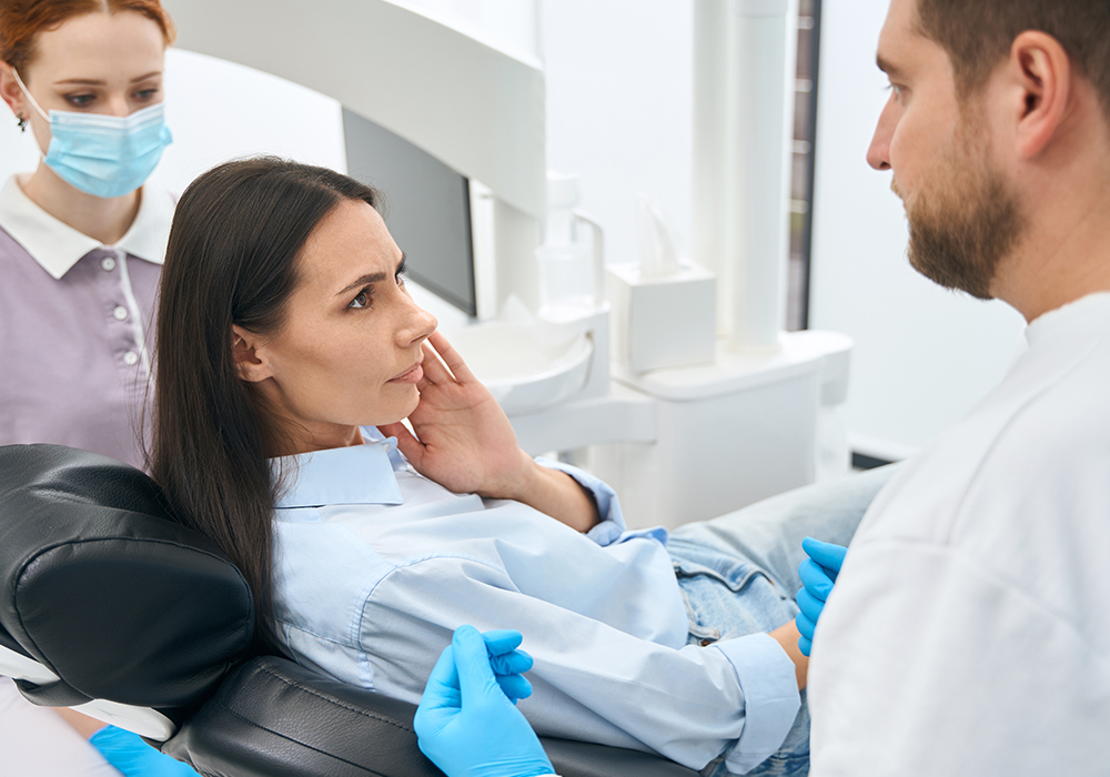 Woman with dental emergency pain at clinic